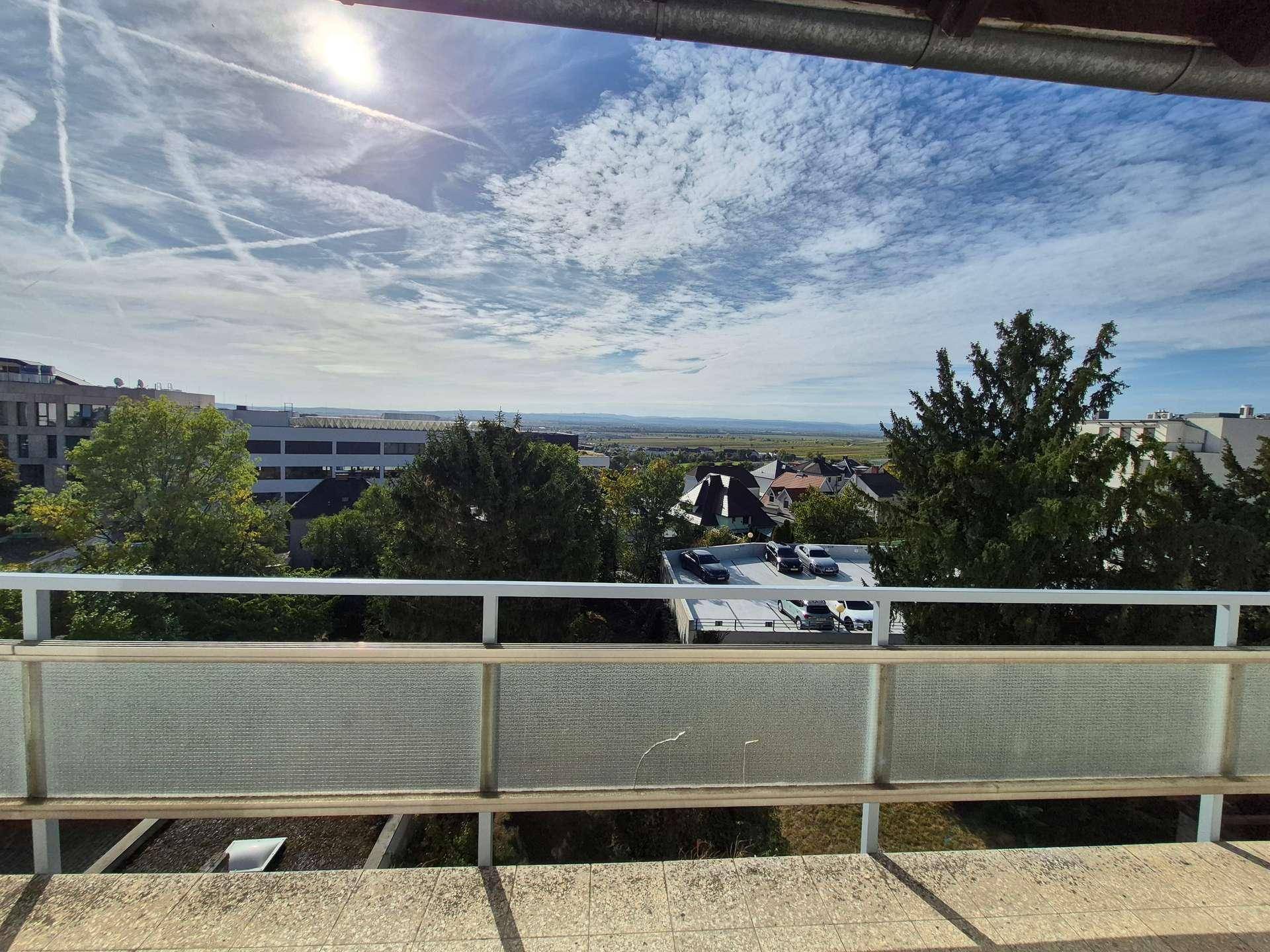 Sonniger Balkon mit Fliesenboden und einem beeindruckenden Blick auf die weite Landschaft.