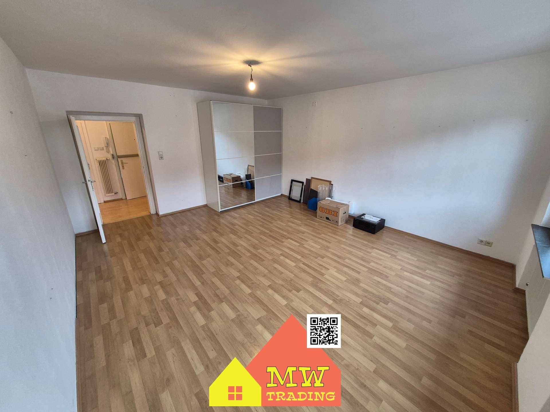 Helles Schlafzimmer mit Laminatboden und einem großen Kleiderschrank, bereit zur individuellen Gestaltung.