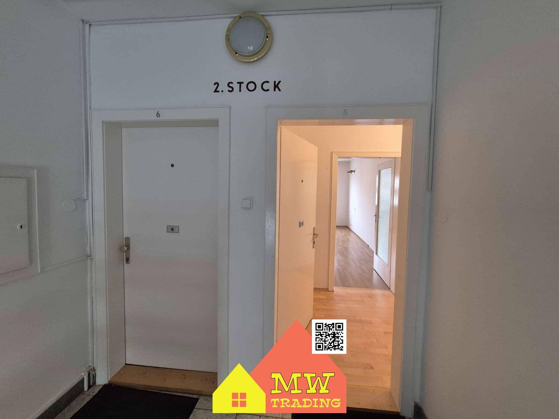 Eingangsbereich im zweiten Stock mit zwei Wohnungstüren und Blick in einen hellen Flur.