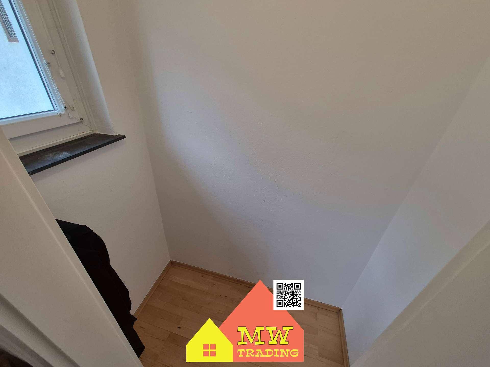 Kleiner Abstellraum mit Fenster und hellem Holzboden, ideal für zusätzlichen Stauraum.