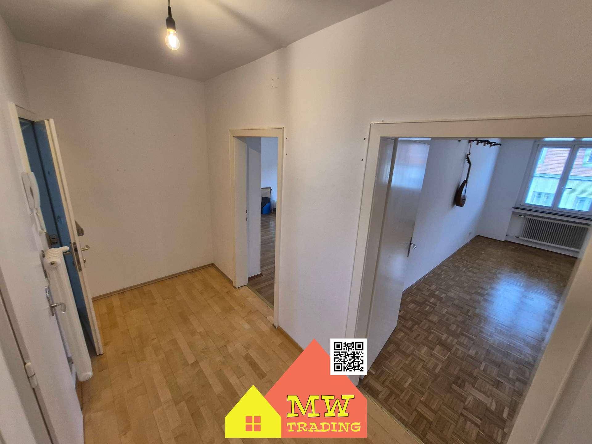 Heller Flur mit Holzboden und mehreren Türen, der verschiedene Räume der Wohnung verbindet.