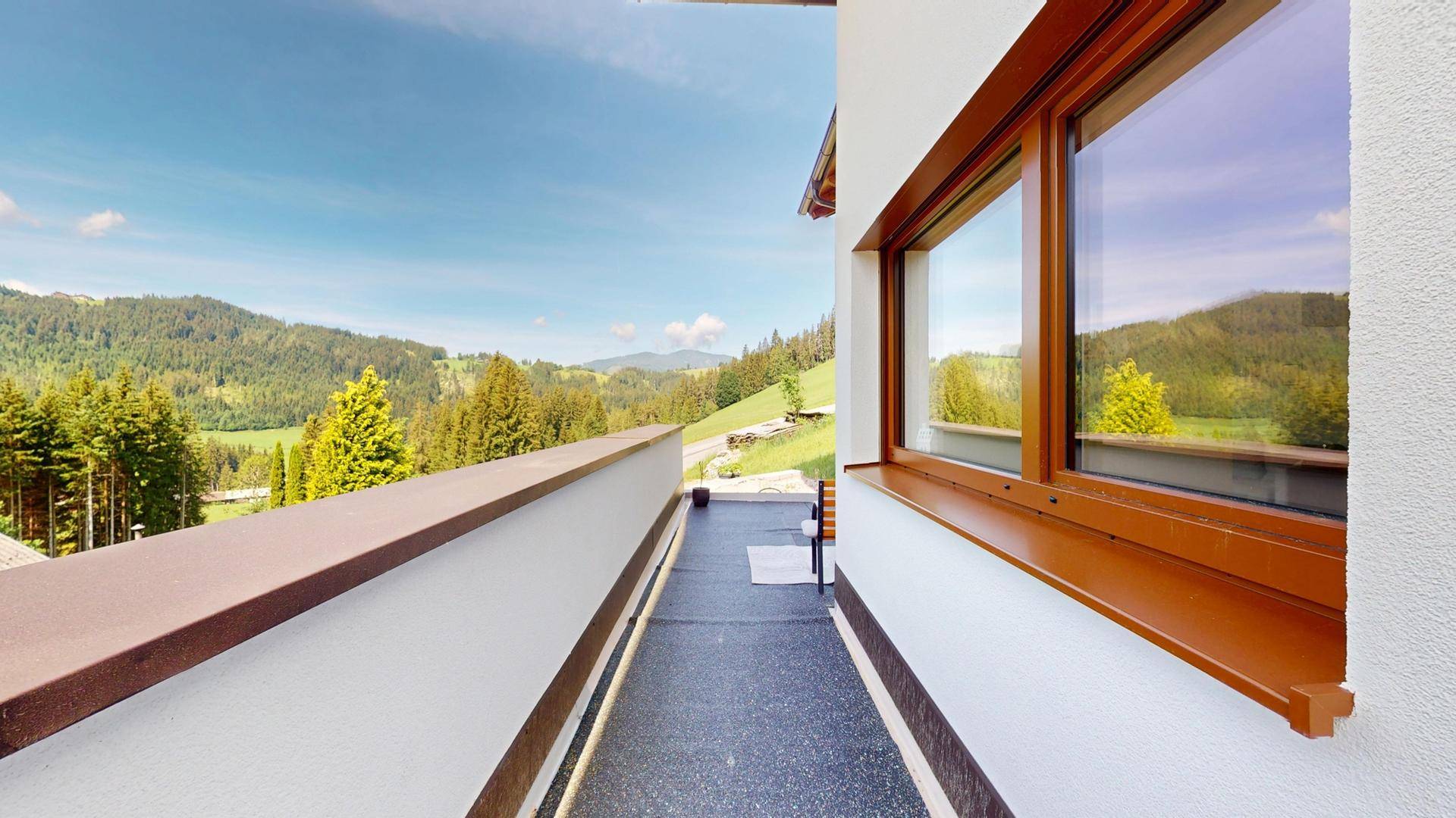 Langer Balkon mit weitem Blick auf die grüne Berglandschaft.