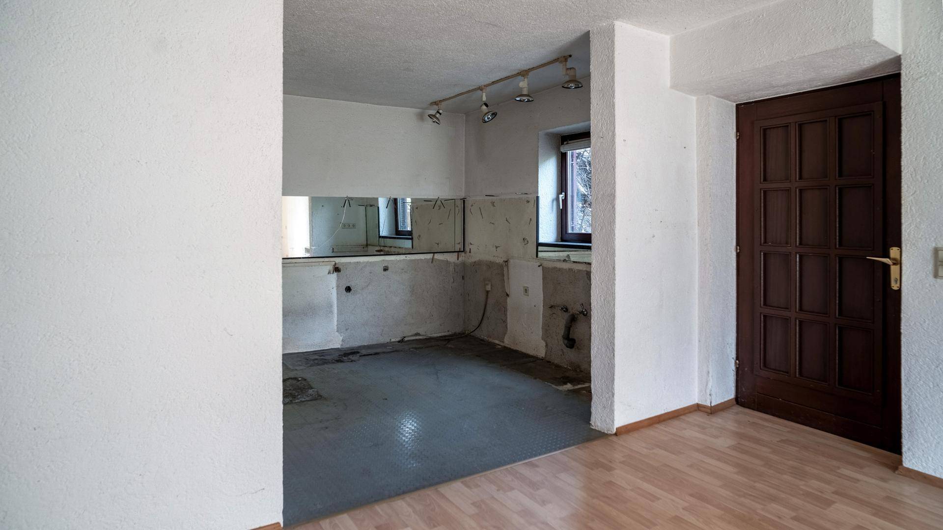 Leerer Küchenraum mit Anschlüssen und Fenster, bereit für eine individuelle Gestaltung.