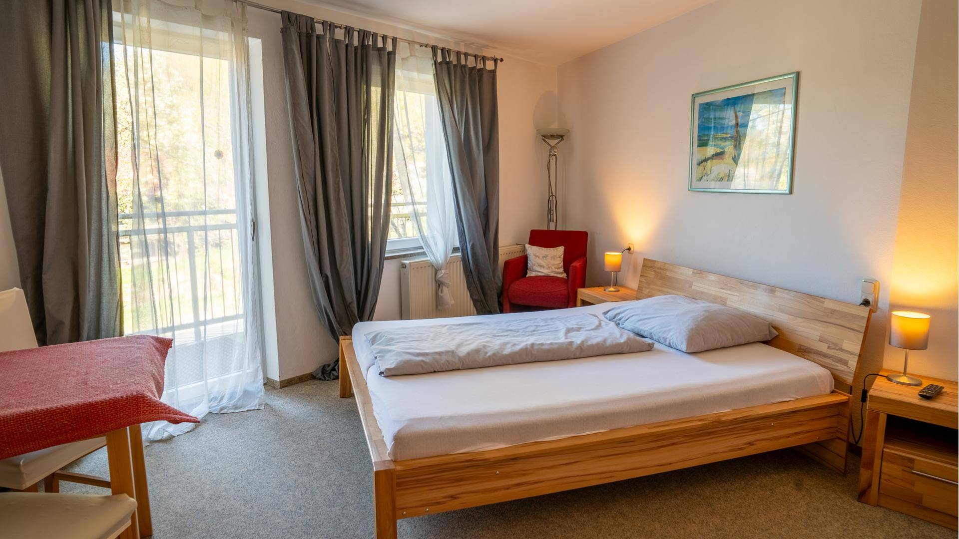 Modern eingerichtetes Schlafzimmer mit hellem Holzdoppelbett und Balkonzugang.