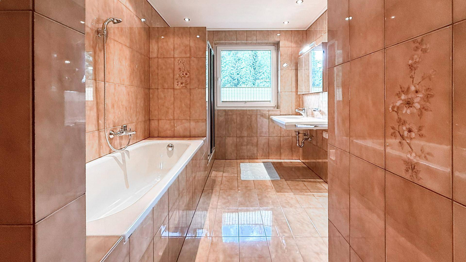 Geräumiges Badezimmer mit Badewanne, Dusche, Doppelwaschbecken und Fenster.