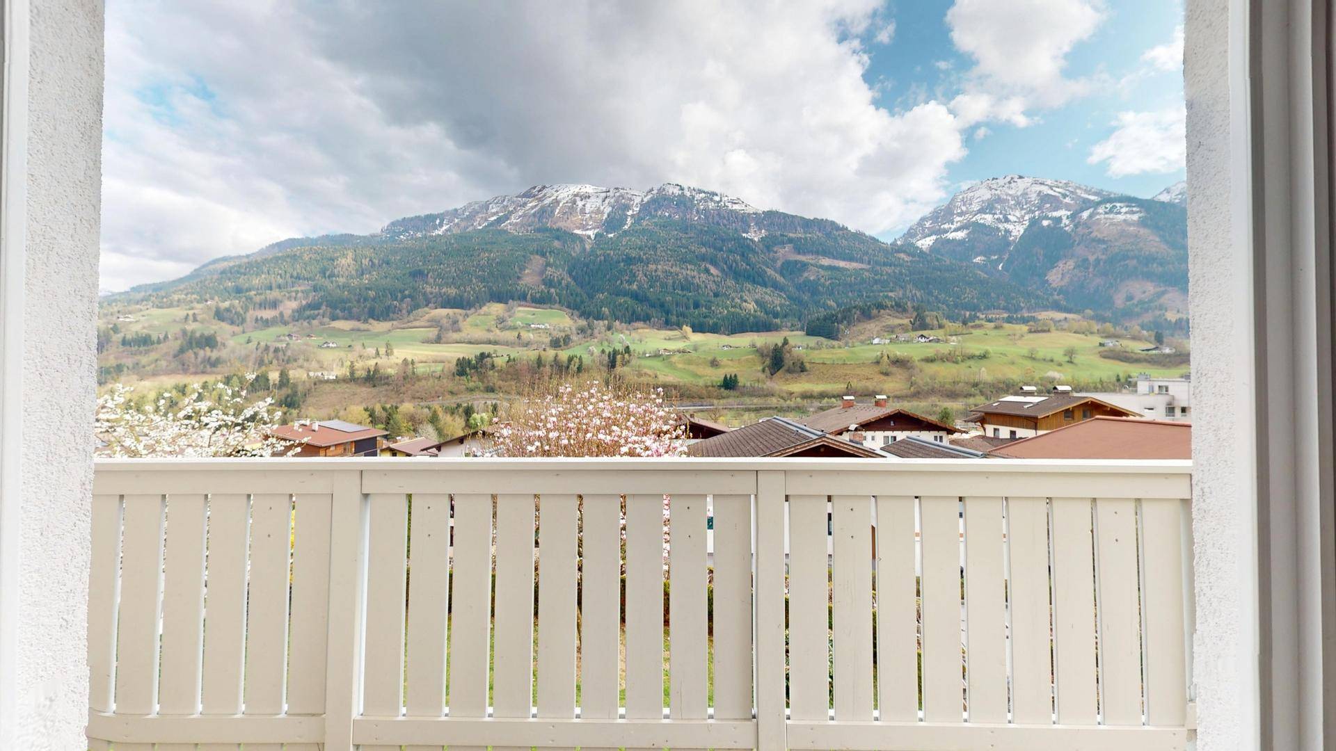 Balkon mit Holzboden und atemberaubendem Panoramablick auf die schneebedeckten Berge.
