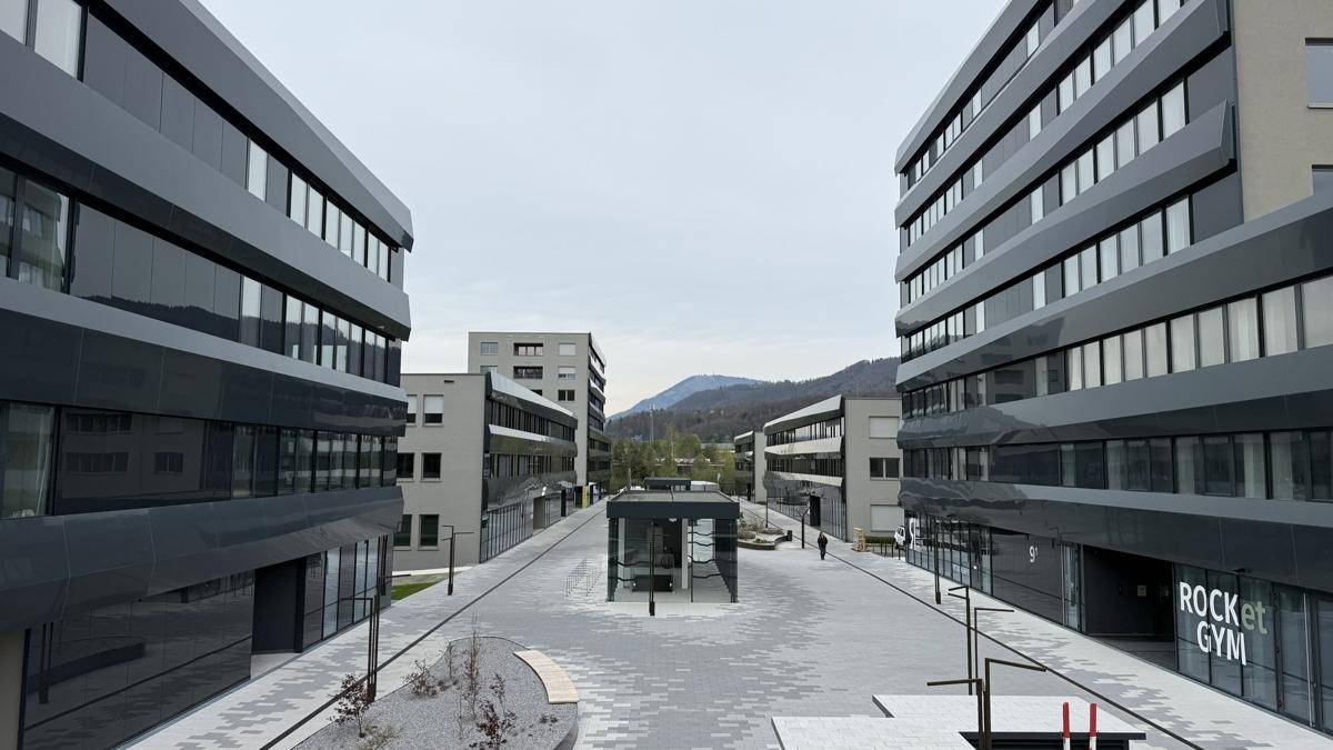 Moderne Bürogebäude in einer gepflegten Anlage mit breiten Gehwegen und Grünflächen.