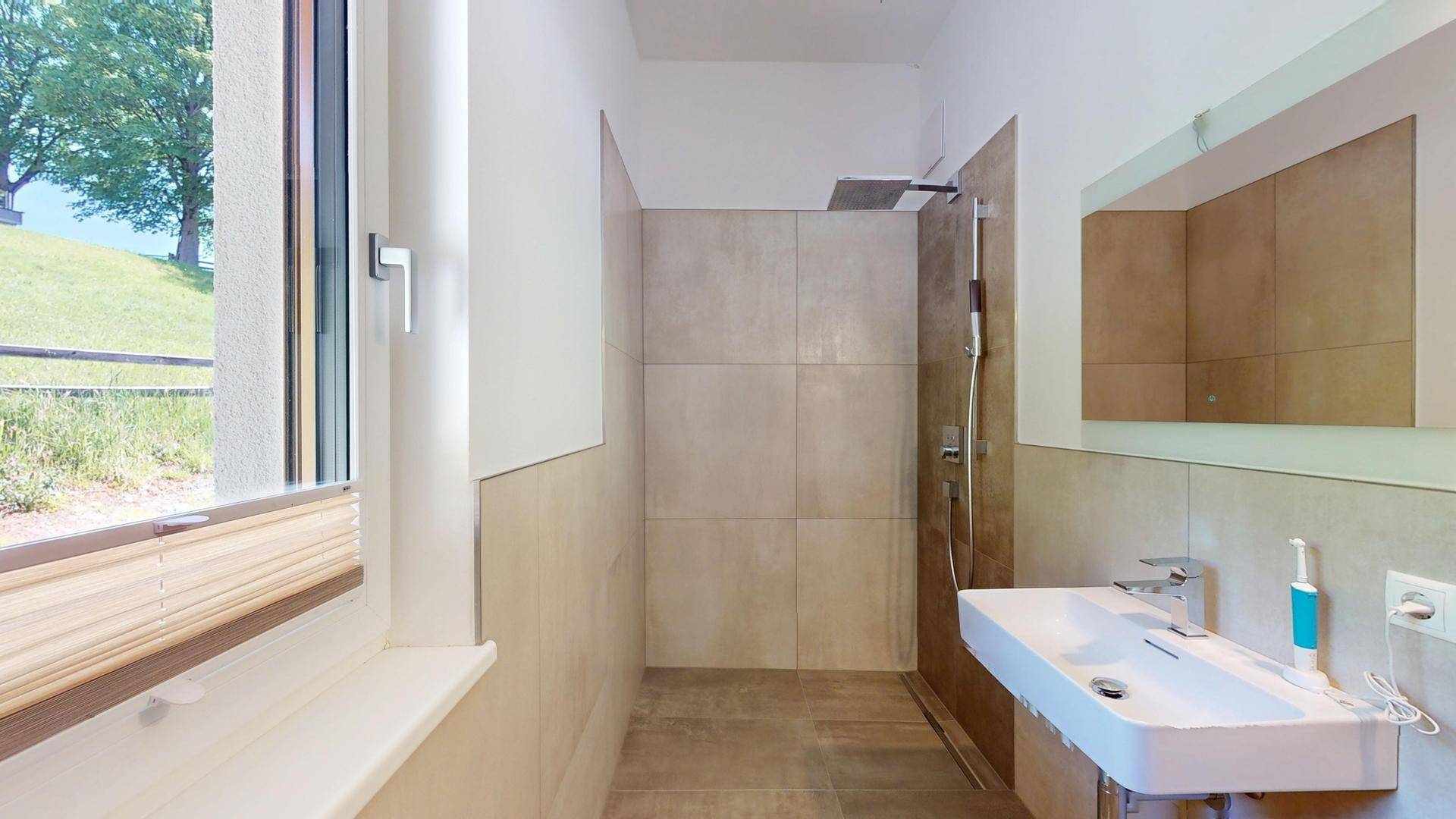 Modernes Badezimmer mit ebenerdiger Dusche, Einzelwaschbecken und Fenster.