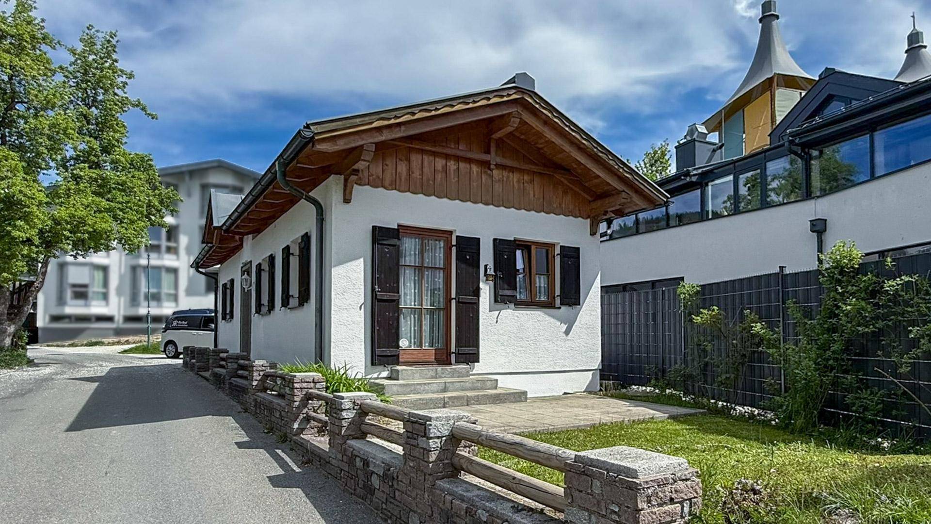 Frontansicht des charmanten Hauses mit Holzelementen und gepflegtem Vorgartenbereich.