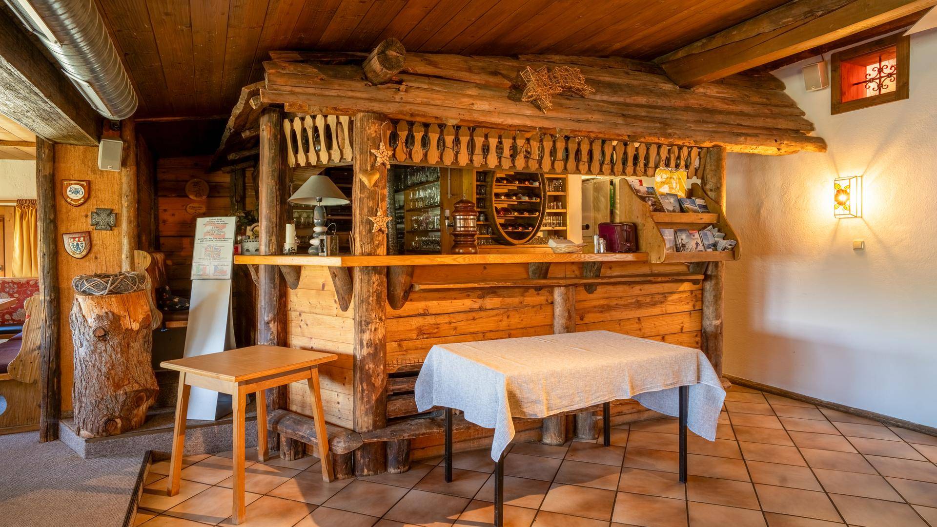 Rustikaler Barbereich mit Holzelementen und Tischen, ideal für gesellige Stunden.