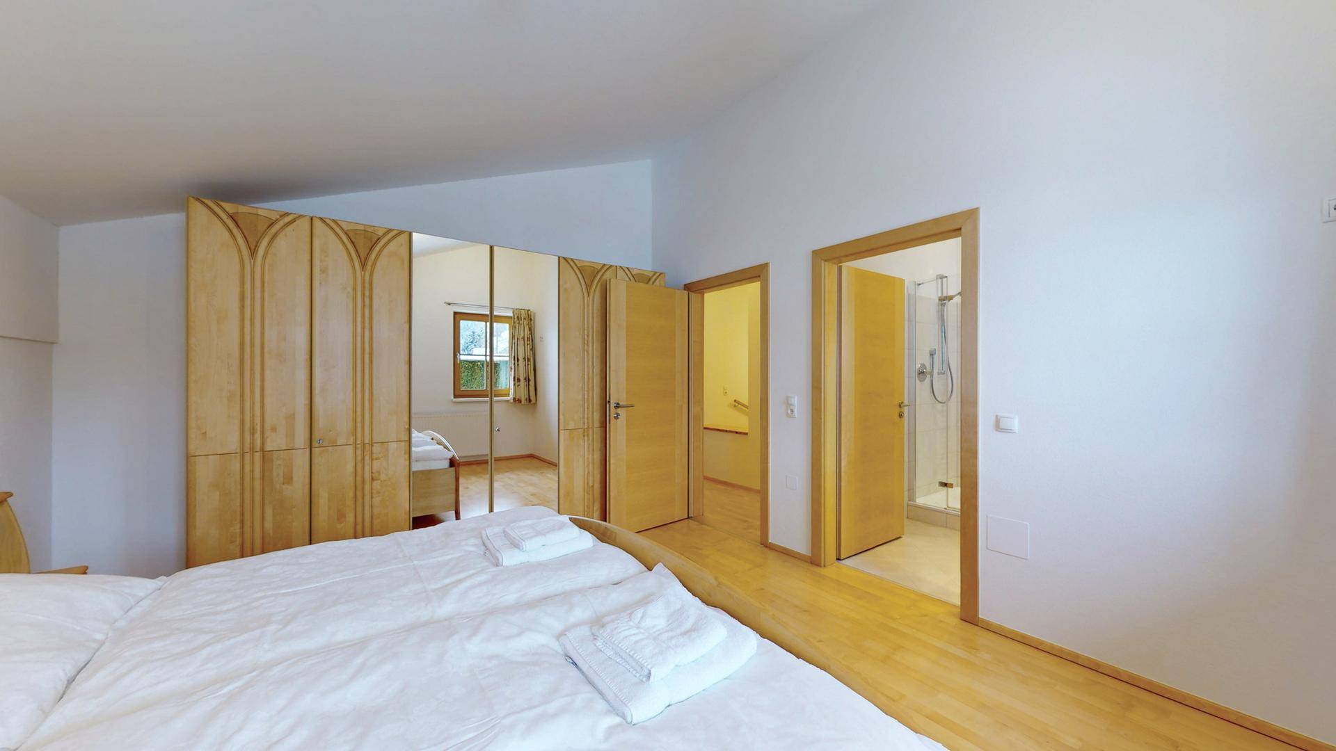 Schlafzimmer mit Einbauschränken und mehreren Türen, die zu angrenzenden Räumen führen.