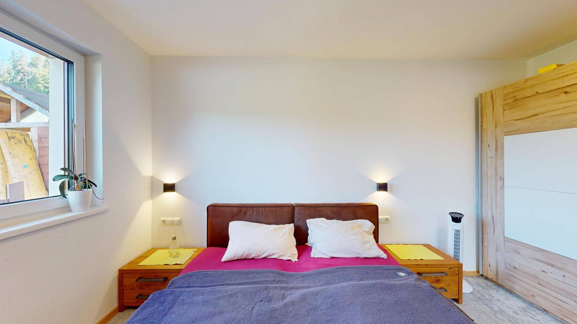 Gemütliches Schlafzimmer mit Doppelbett, Holzelementen und Fenster.