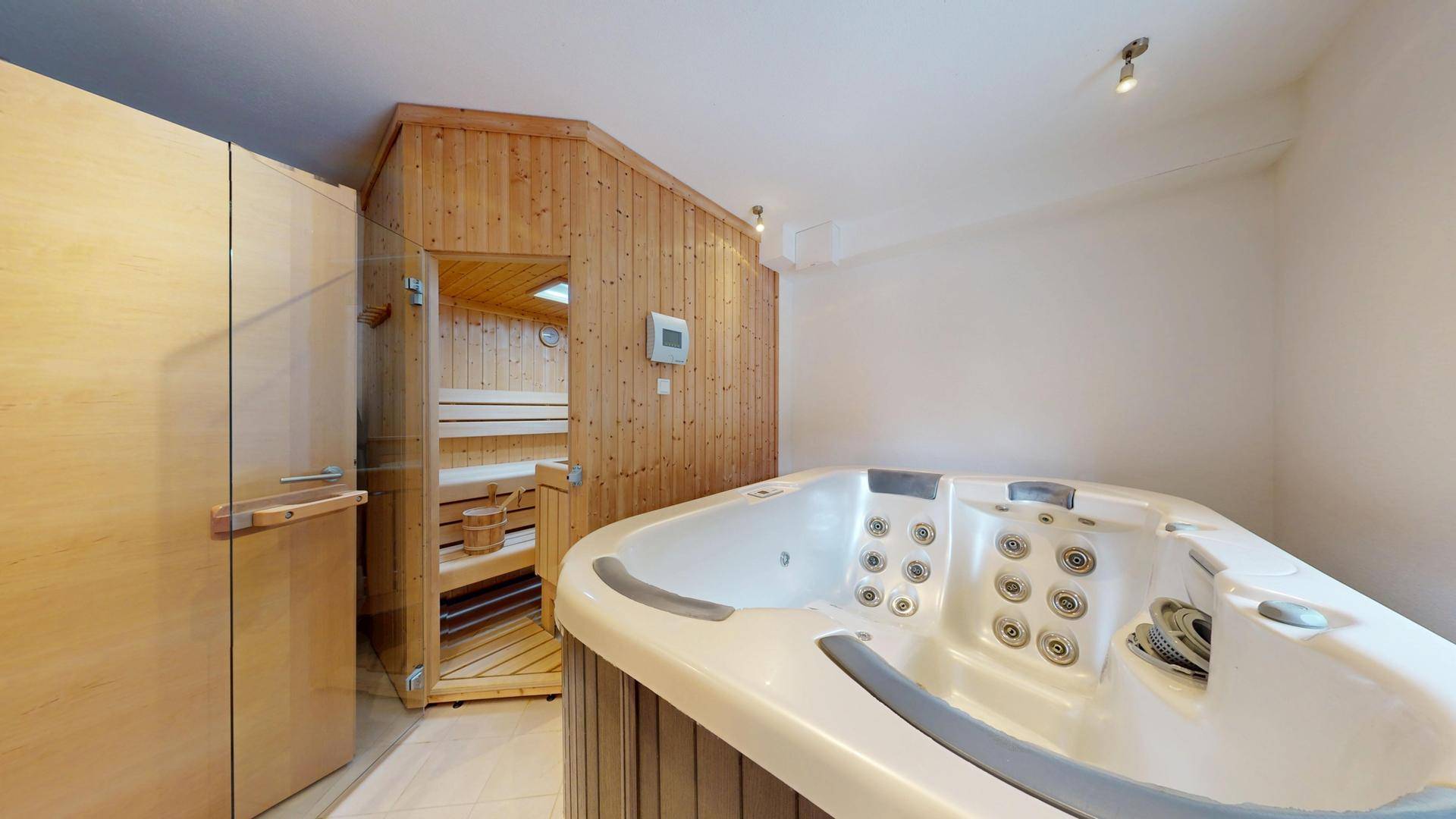 Wellnessbereich mit Whirlpool und einer holzvertäfelten Sauna für Entspannung.