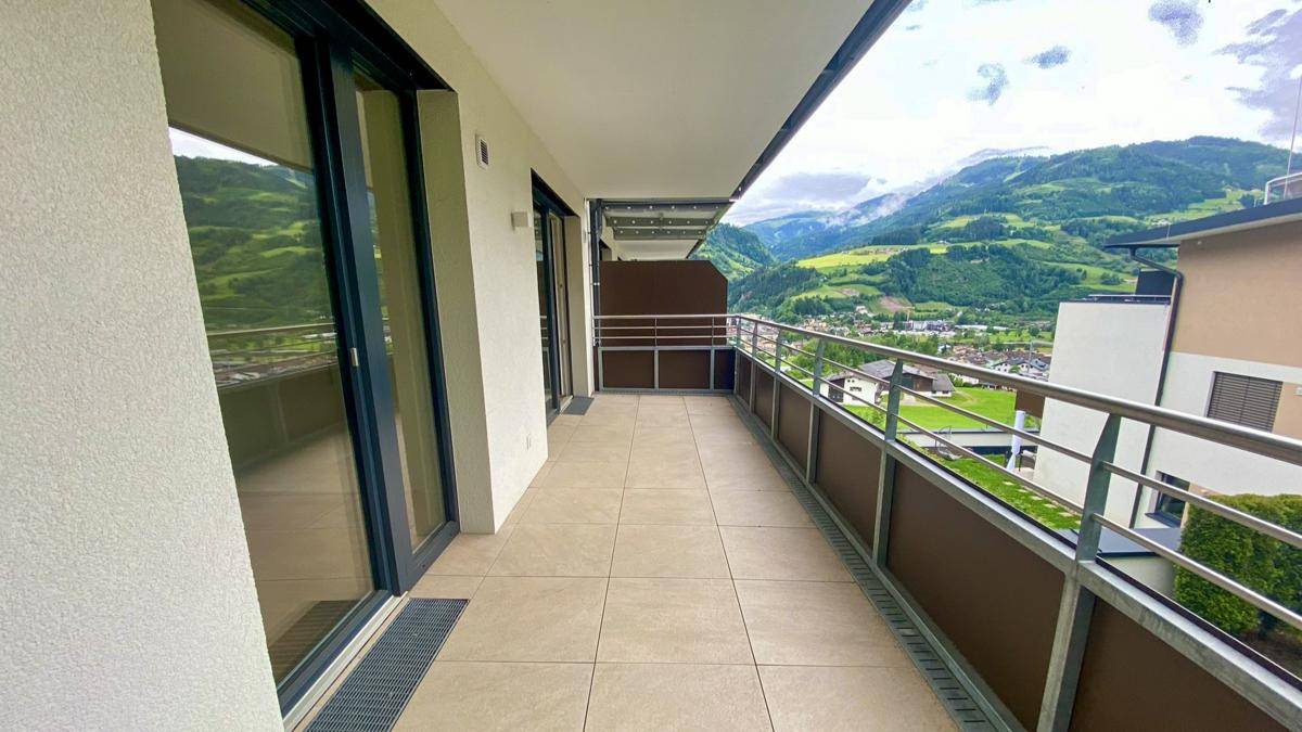 Geräumiger Balkon mit Fliesenboden und herrlichem Blick auf die umliegenden Berge.