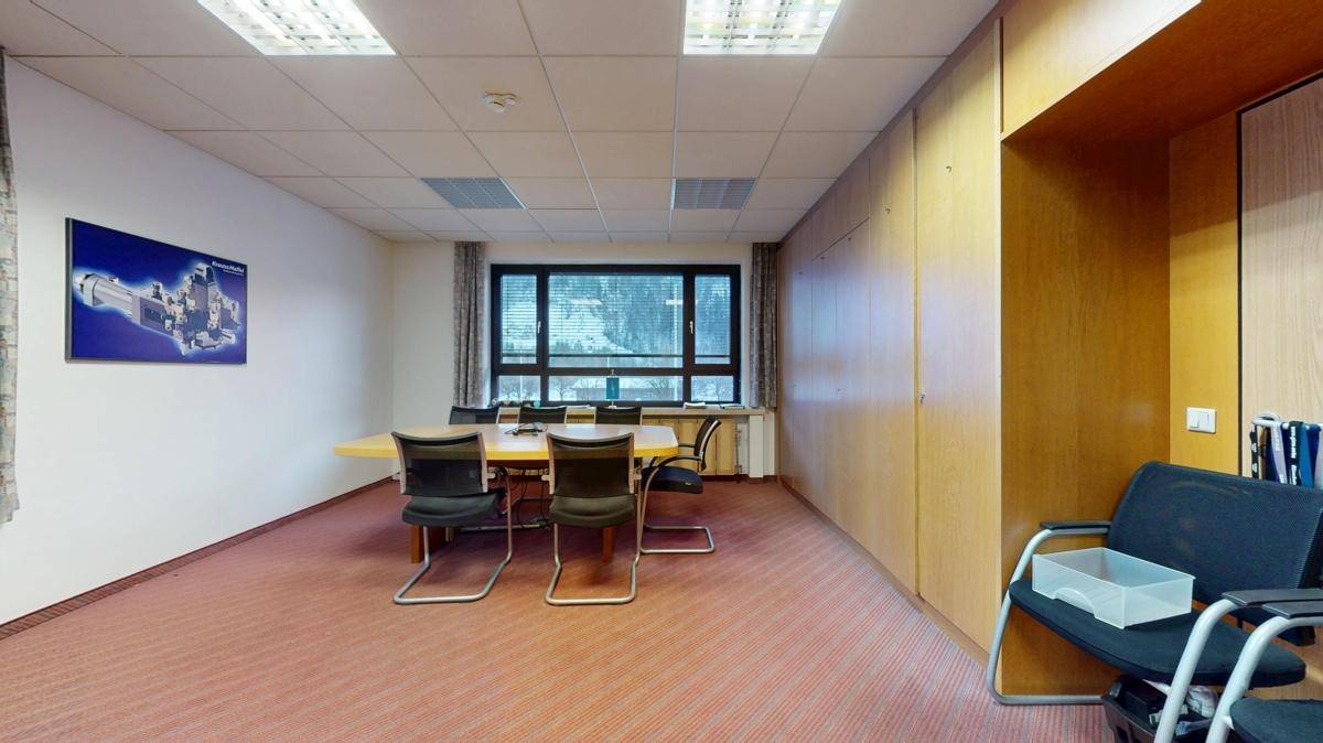 Konferenzraum mit Teppichboden, großem Tisch und Stühlen, ideal für Besprechungen und Präsentationen.