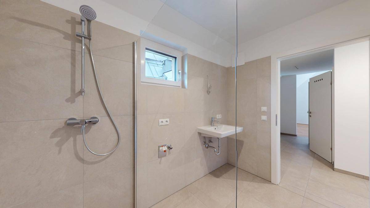 Modernes Badezimmer mit begehbarer Dusche, Fliesenboden und einem Fenster für Tageslicht.