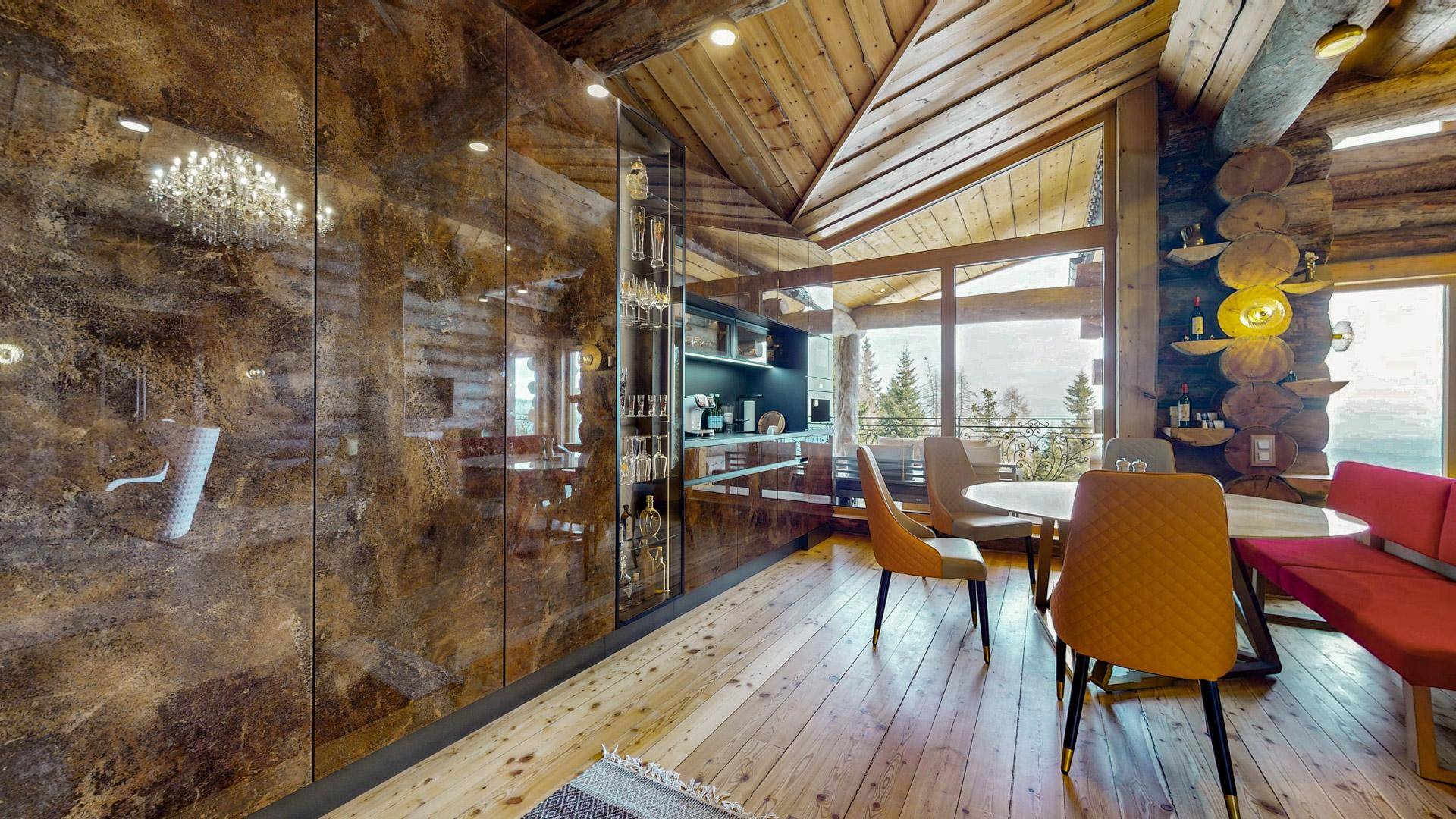 Eleganter Essbereich mit Holzböden, modernen Stühlen und einem großen Fenster mit Bergblick.