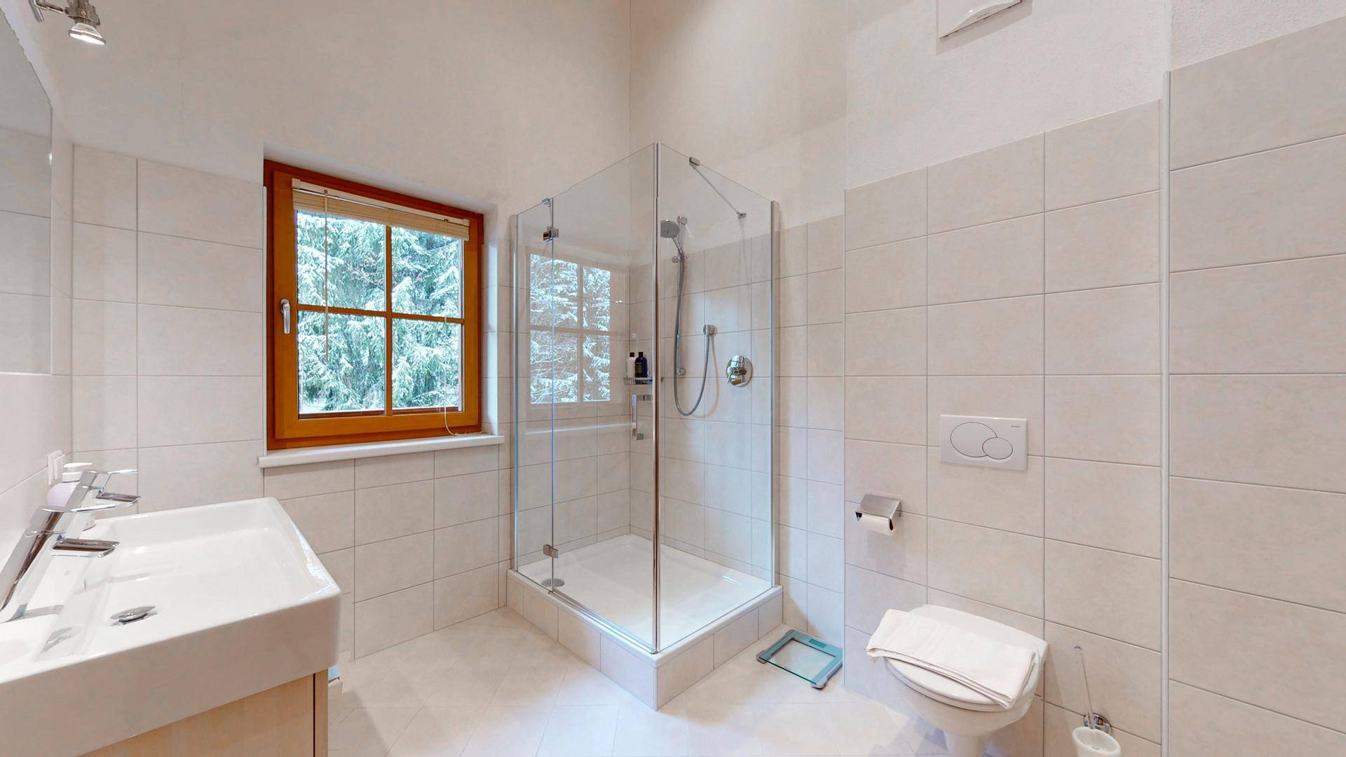 Modernes Badezimmer mit Duschkabine, Doppelwaschbecken und Fenster für Tageslicht.