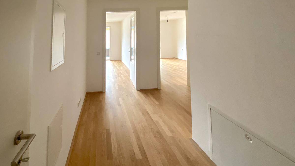 Heller Flur mit Parkettboden, der zu verschiedenen Zimmern der Wohnung führt.