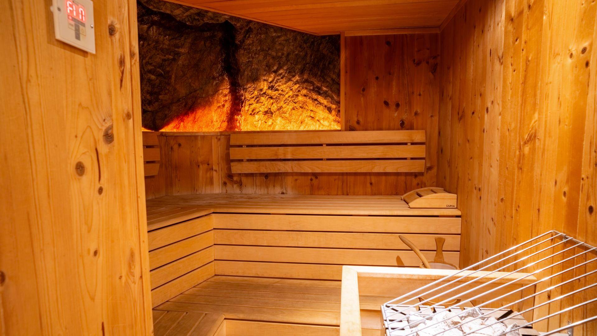 Traditionelle Holzsauna mit Bänken und Heizofen, ideal zur Entspannung.