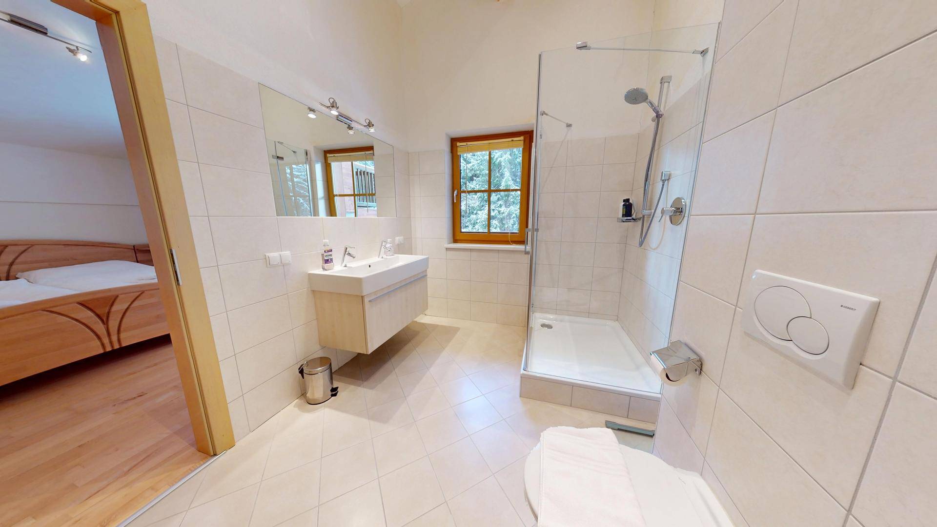 Modernes Badezimmer mit Dusche, Waschtisch und Fenster für natürliches Licht.