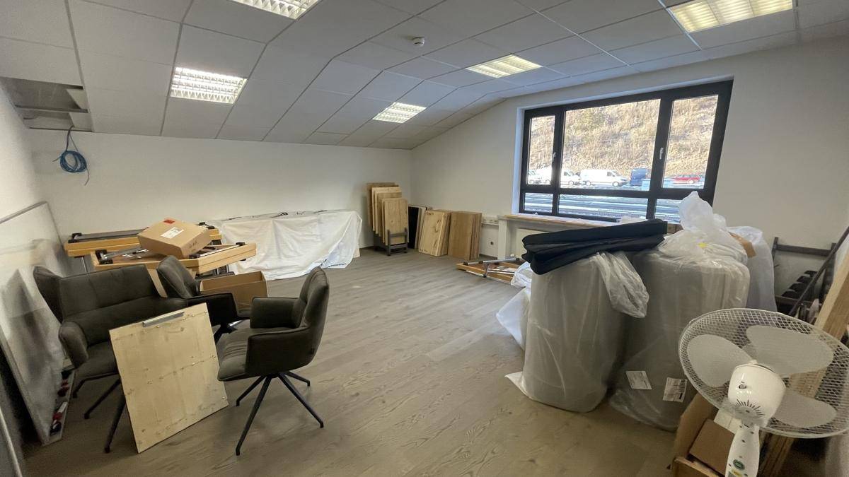 Leerer Büroraum mit hellem Boden und großem Fenster, bietet viel Potenzial für neue Mieter.