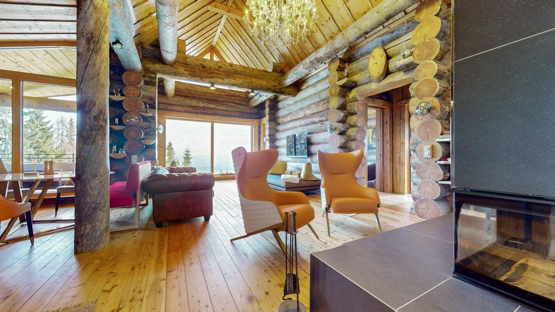 Offener Wohnbereich mit Kamin, Holzböden und stilvollen Sesseln, die zum Entspannen einladen.