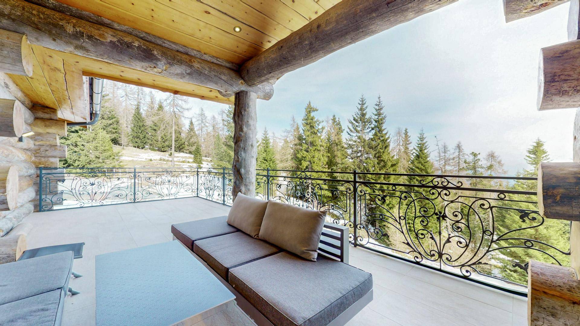 Großer Balkon mit schmiedeeisernem Geländer und Loungemöbeln, ideal für entspannte Stunden im Freien.