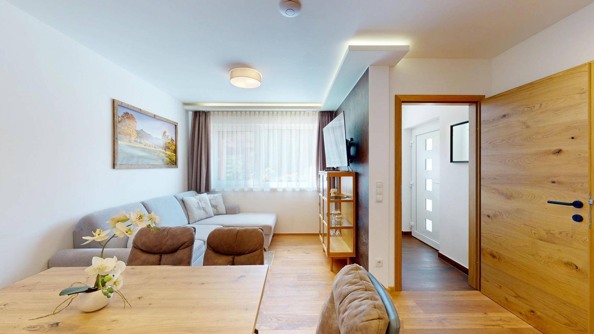 Heller Wohn- und Essbereich mit Sofa, Esstisch und Holzboden.