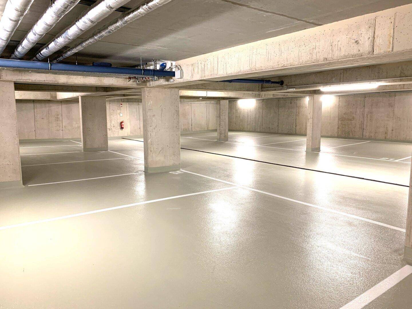 Geräumige Tiefgarage mit markierten Stellplätzen und Betonkonstruktion.