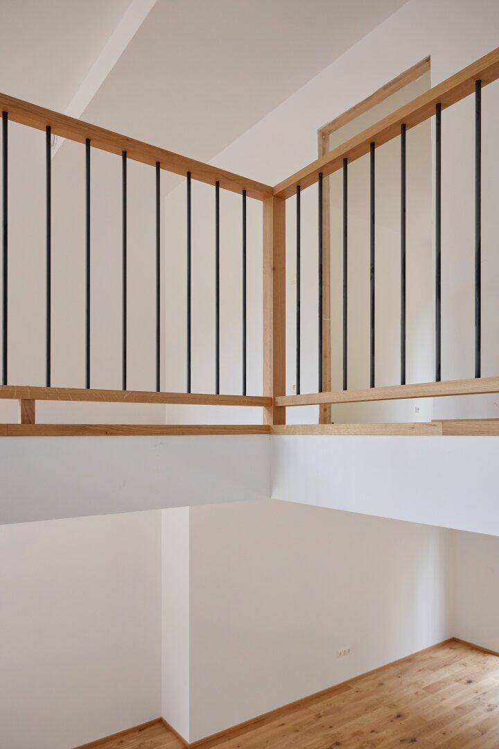Blick von der Galerie auf den unteren Bereich, der durch die großen Fenster hell erleuchtet wird.