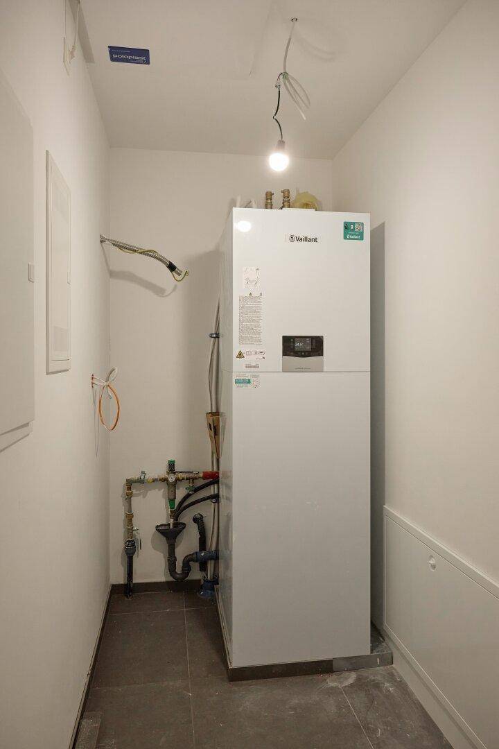 Technikraum mit moderner Heizungsanlage und sichtbaren Installationen.