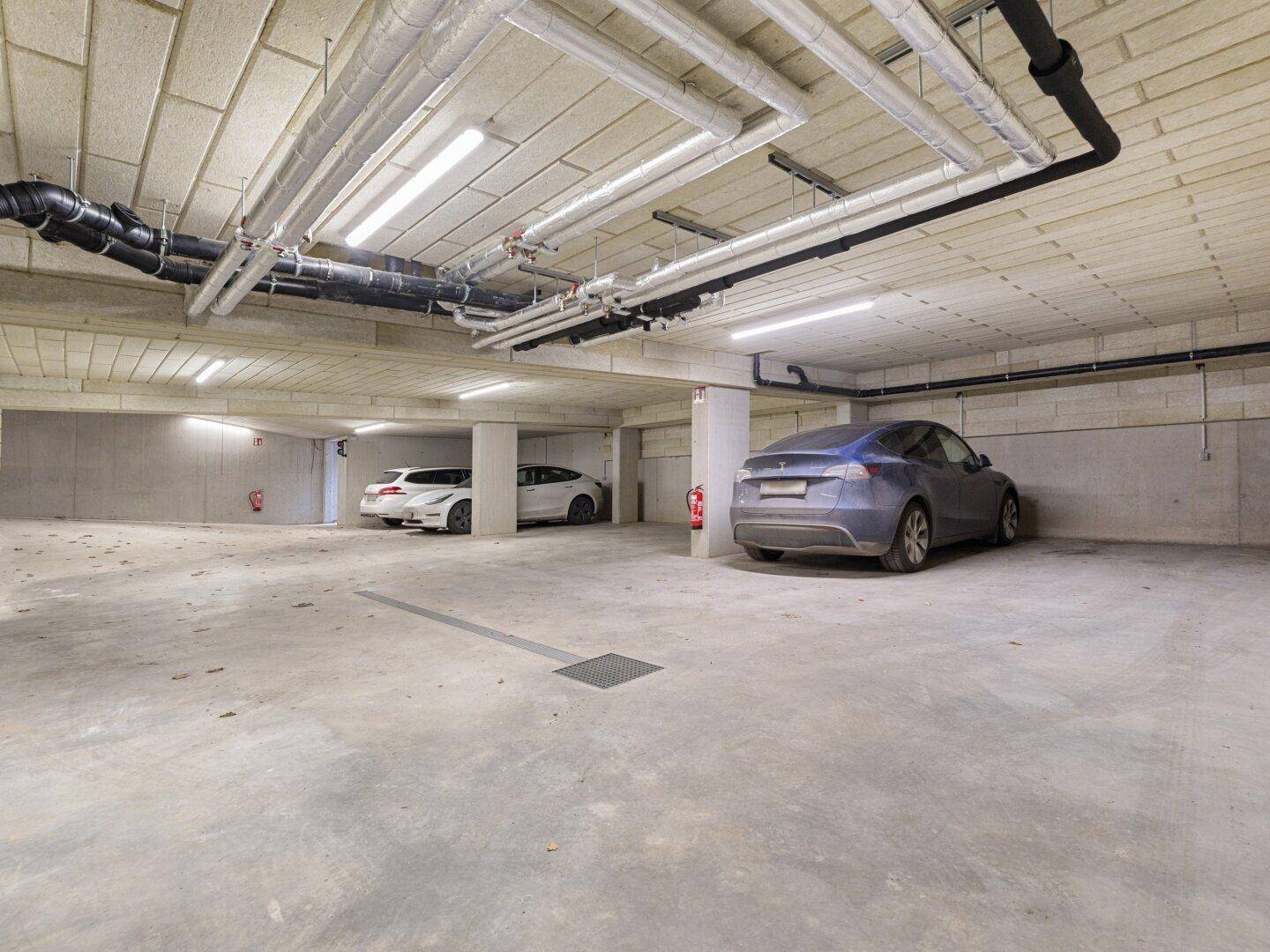 Geräumige Tiefgarage mit mehreren Stellplätzen und moderner Beleuchtung.