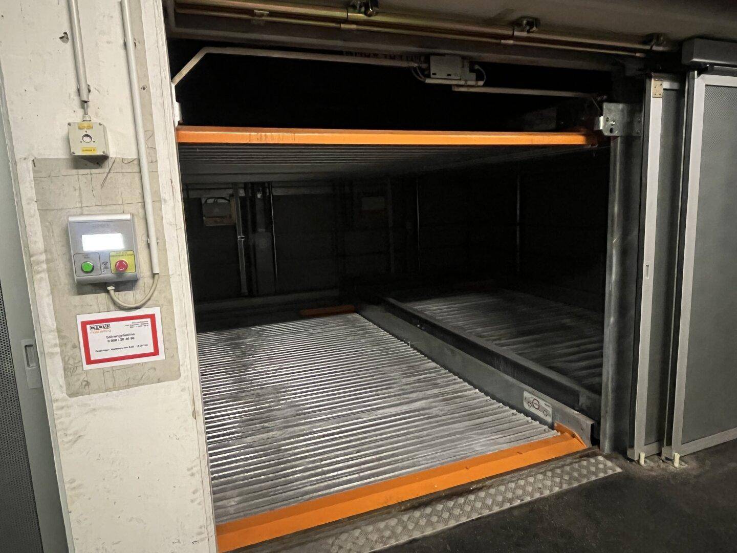 Blick in das mechanische Parksystem einer Tiefgarage, bereit zur Aufnahme eines Fahrzeugs auf der Plattform.