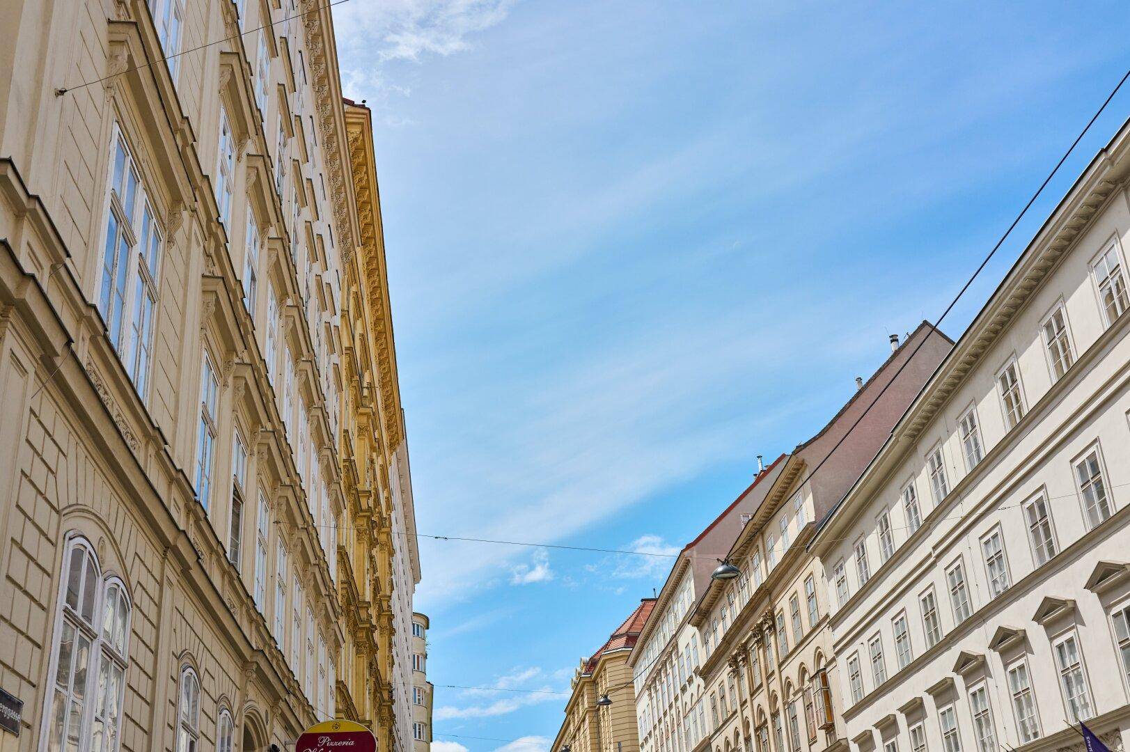 Historische Gebäude mit vielen Fenstern unter einem klaren blauen Himmel in der Stadt.