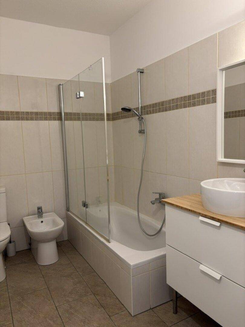 Modernes Badezimmer mit Badewanne, Dusche, WC, Bidet und stilvollem Waschtisch.