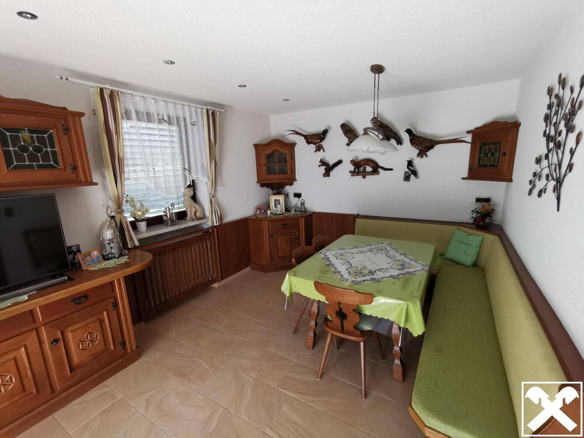 Gemütlicher Essbereich mit Eckbank, Holztisch und traditioneller Dekoration.