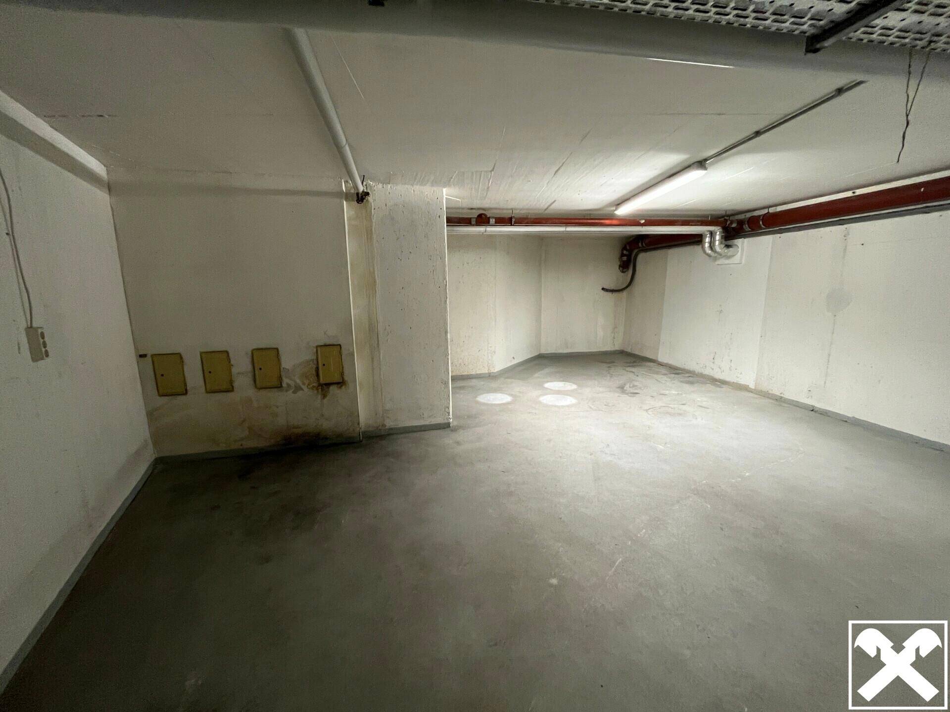 Geräumiger Kellerraum mit Betonboden und sichtbaren Leitungen an der Decke, ideal als Lagerfläche.
