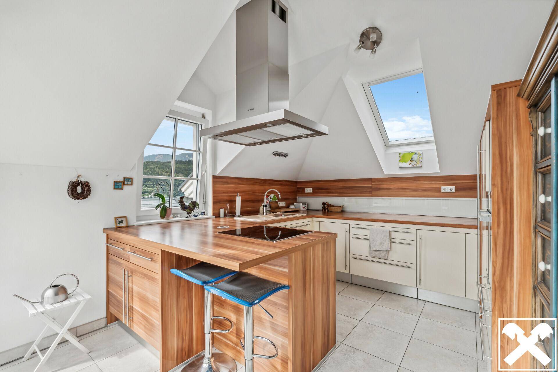 Moderne Küche mit Holzarbeitsplatten, Kochinsel und Dachfenstern für viel Tageslicht.