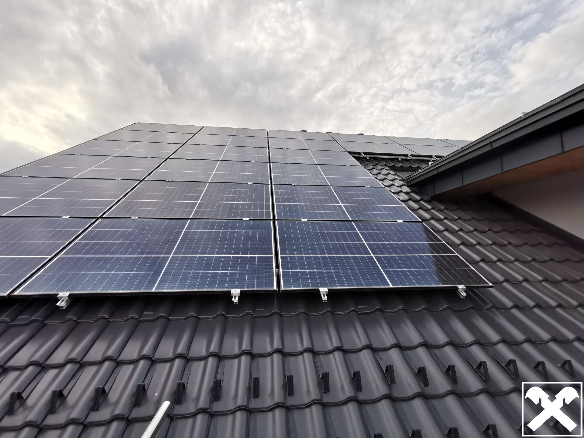 Photovoltaikanlage auf dem dunklen Ziegeldach des modernen Wohngebäudes.