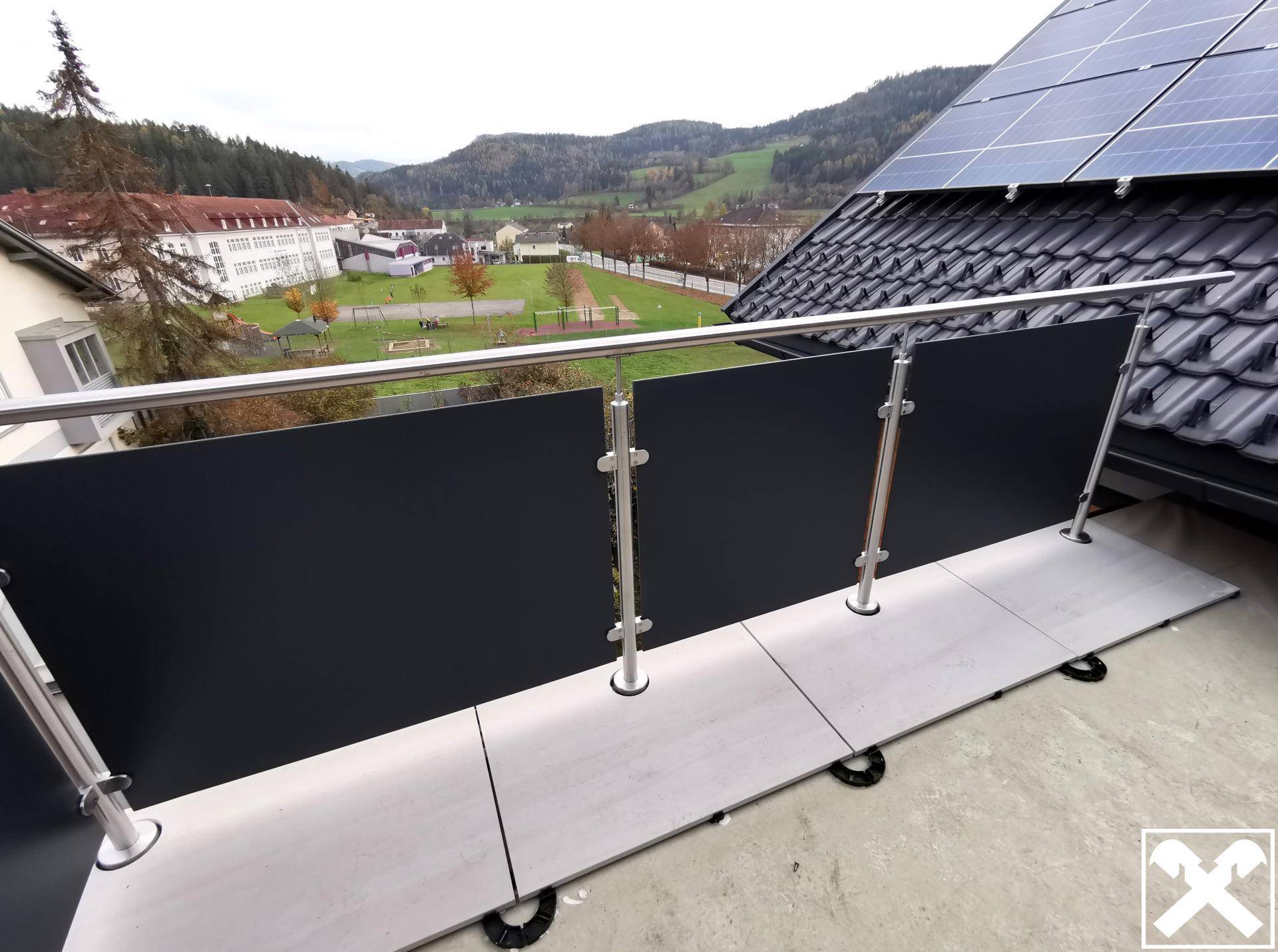 Moderner Balkon mit Metallgeländer und Fliesenboden, bietet einen weiten Blick auf die Landschaft.
