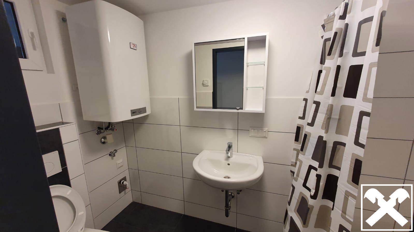 Modernes Badezimmer mit Dusche, Waschbecken und Spiegelschrank, hell gefliest und funktional.