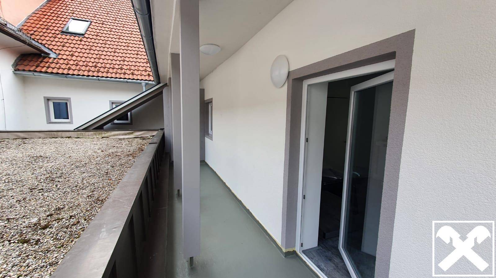 Langer, schmaler Balkon mit Blick auf das Dach und die Umgebung des Gebäudes, ideal zum Entspannen.