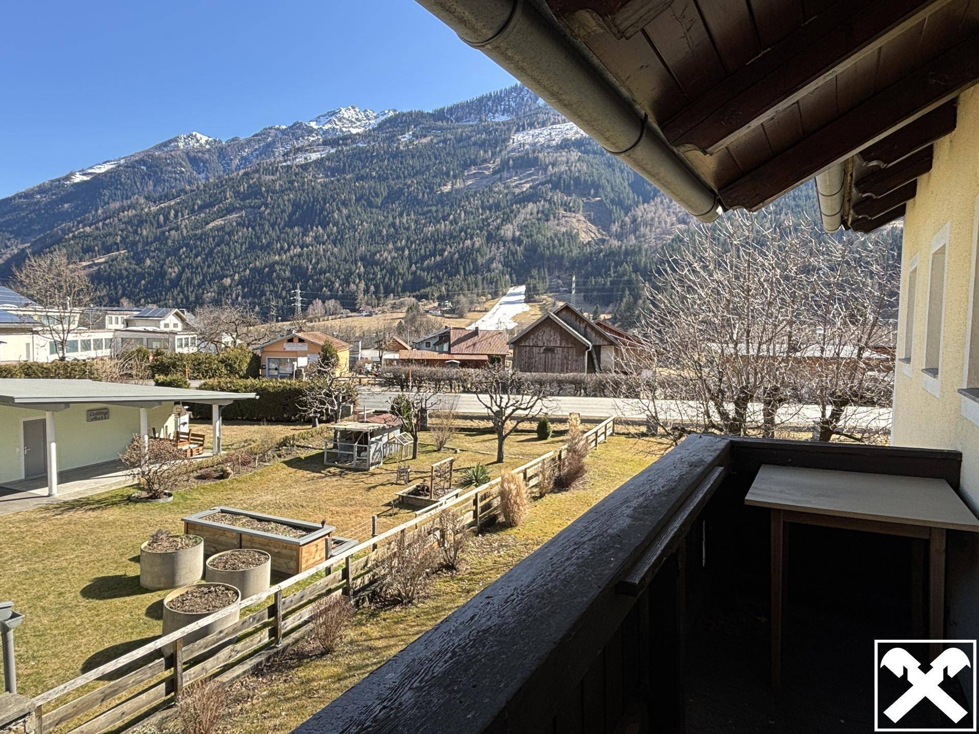 Balkon mit Bergblick und Blick auf den Gartenbereich der Unterkunft.