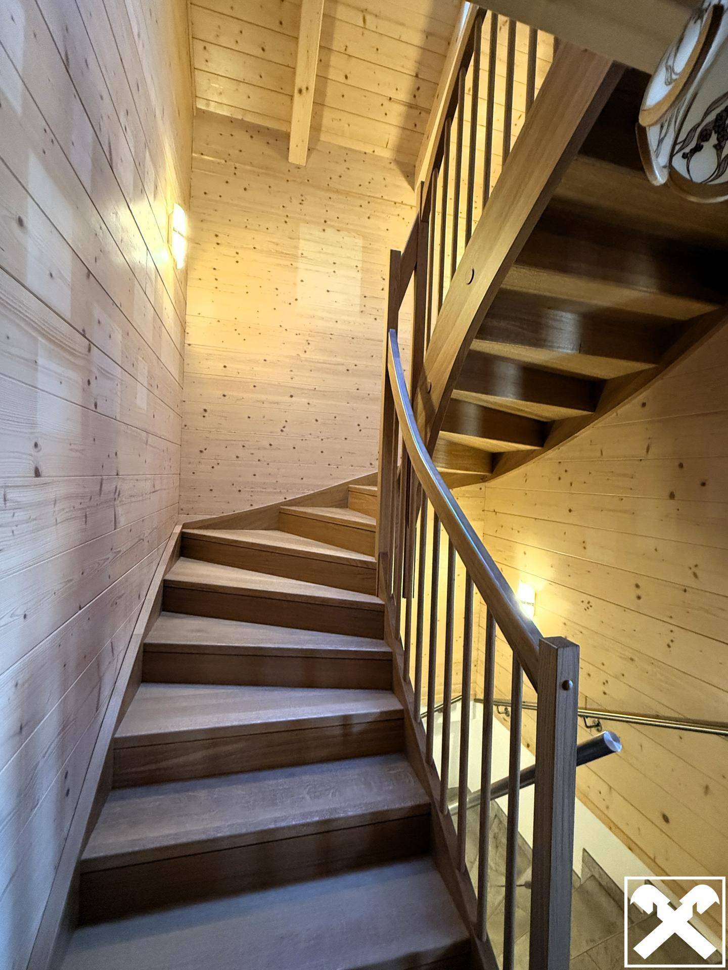Elegante Holztreppe mit Geländer, die die verschiedenen Etagen des Hauses verbindet.