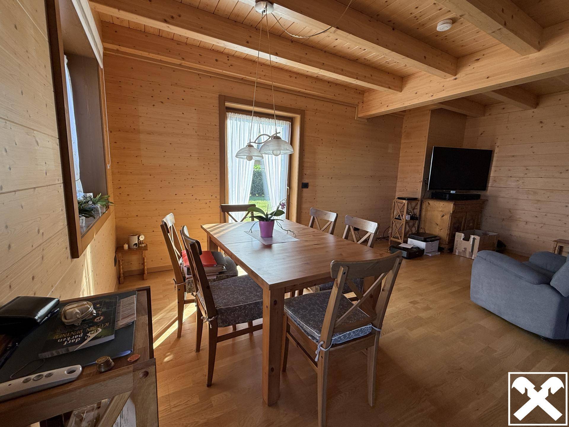 Gemütlicher Essbereich mit Holztisch und Stühlen, angrenzend an den Wohnbereich.