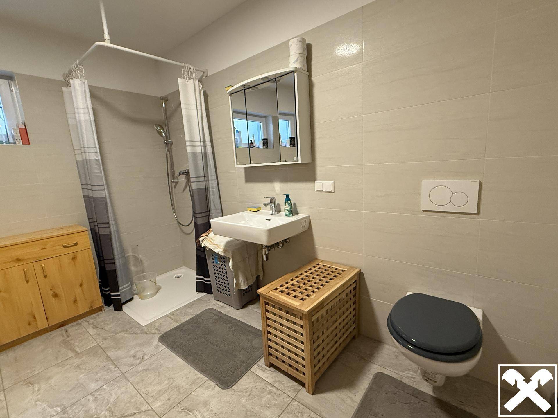 Funktionales Badezimmer im Untergeschoss mit Dusche, WC und Waschbecken.