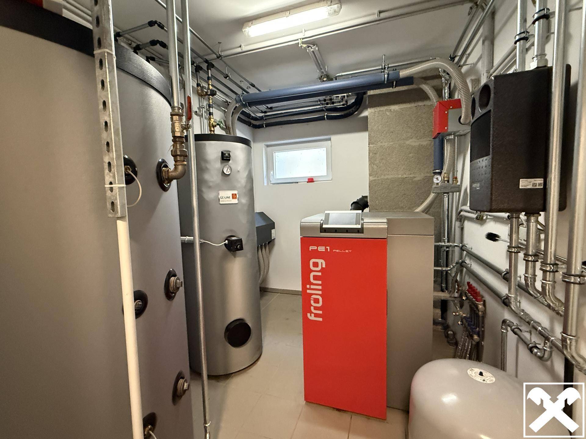 Technikraum mit moderner Pelletheizung und Warmwasserspeichern.