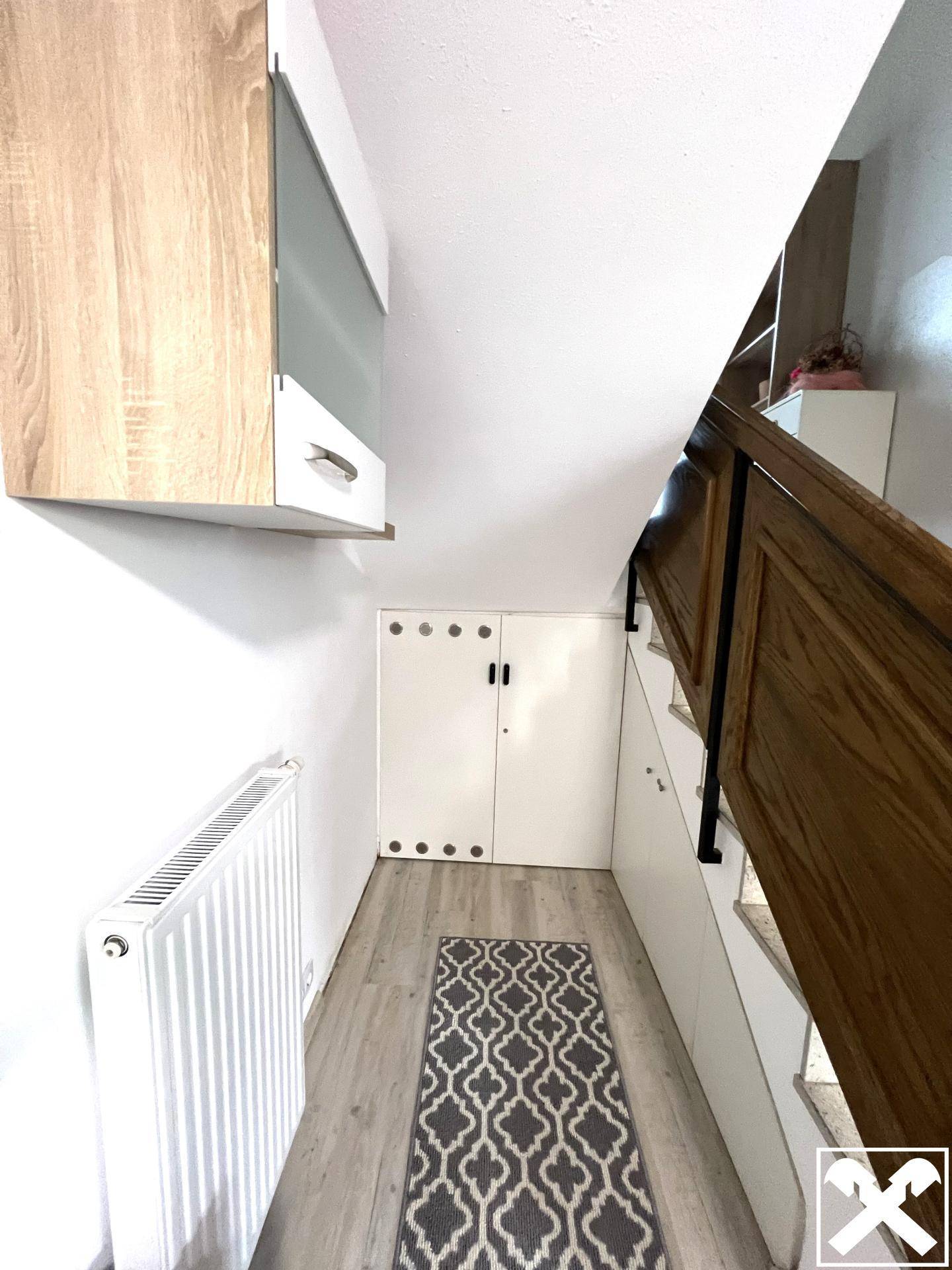 Flur mit Stauraum unter der Treppe und einem Heizkörper an der Wand.