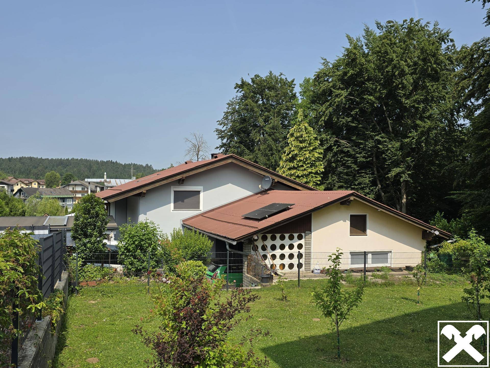 Rückansicht des Hauses mit großem Garten und einem Nebengebäude im Grünen.